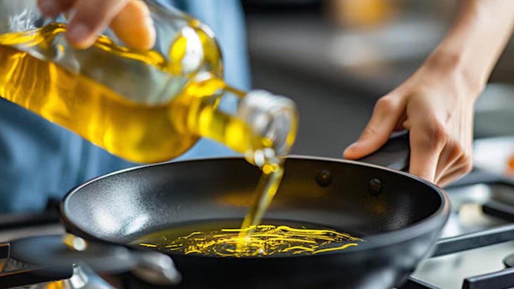 Óleo sendo colocado na frigideira para preparo de alimentos na cozinha
