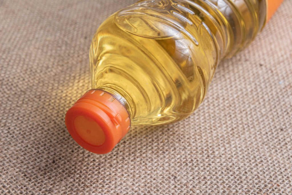 Garrafa com óleo de palma utilizado na produção de alimentos, biocombustíveis e produtos industriais.