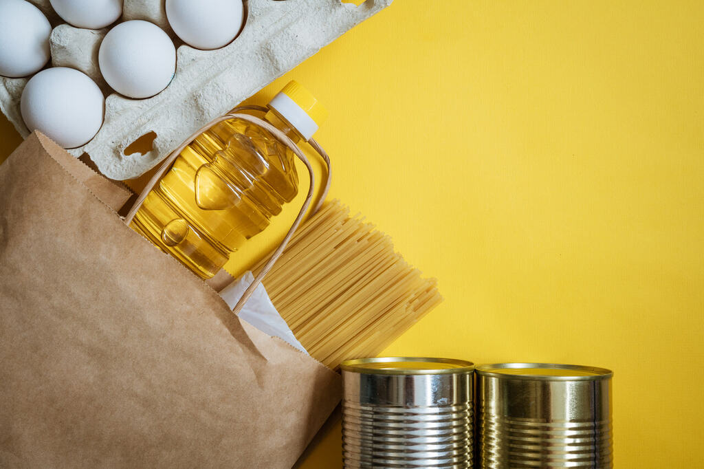 óleo de algodão com ovos, macarrão e alimentos básicos sobre fundo amarelo