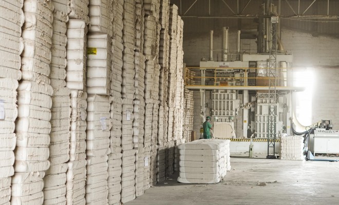 Fardos de linter de algodão empilhados em galpão industrial para produção de papel